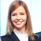 a woman in a suit smiling for the camera.